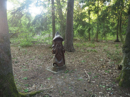 A little man stands in the forest - at the start of the route
